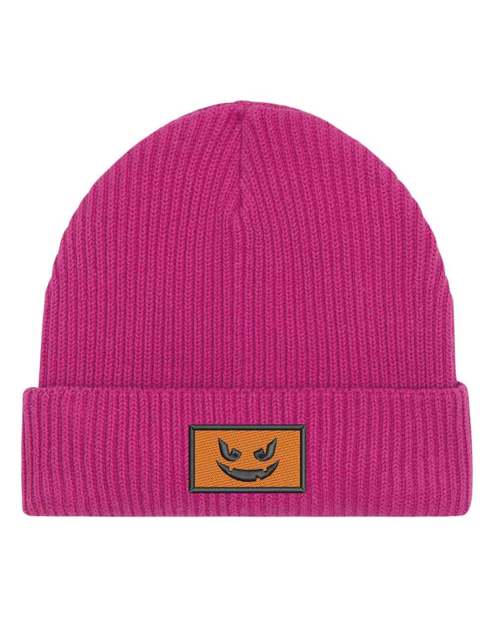 Căciulă roz din tricot reiat cu manșetă întoarsă, brodată cu o față de dovleac Jack-o'-lantern neagră într-un chenar dreptunghiular, un accesoriu amuzant inspirat de Halloween.