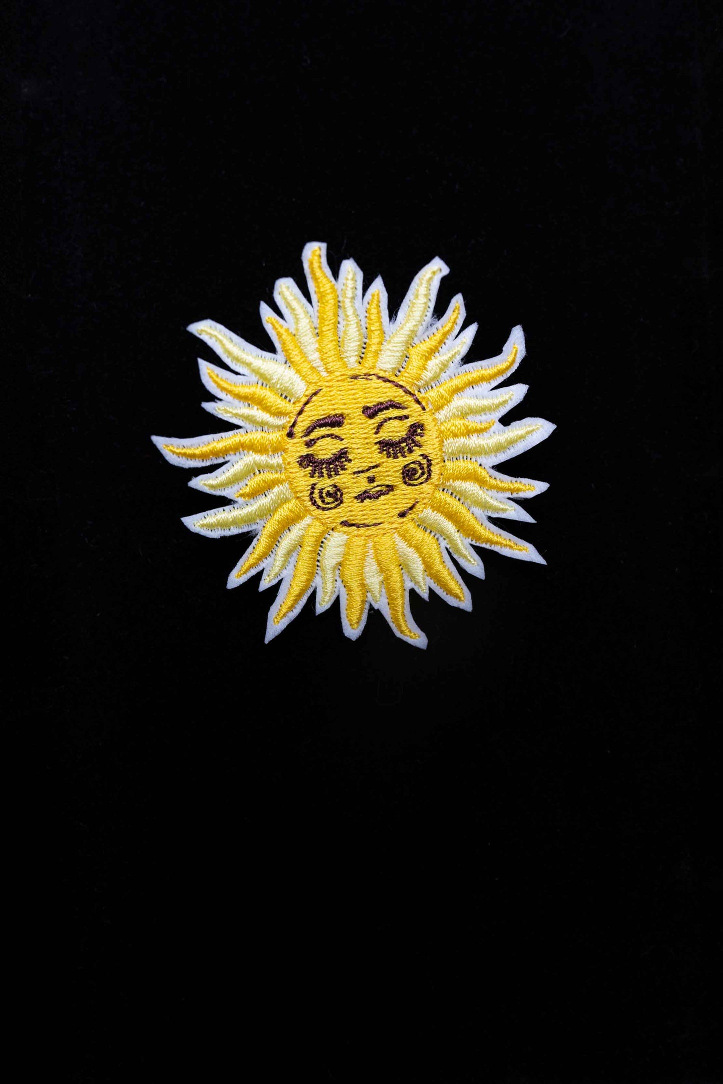 An embroidered sun brooch, a symbol of positivity and brightness. A unique accessory to bring warmth to your look!