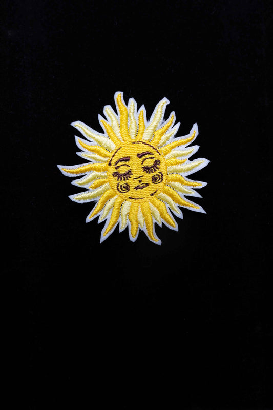An embroidered sun brooch, a symbol of positivity and brightness. A unique accessory to bring warmth to your look!