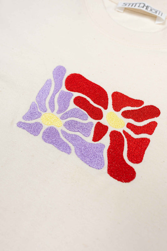 A luxury women’s t-shirt featuring bespoke floral embroidery, made from 100% organic cotton.
