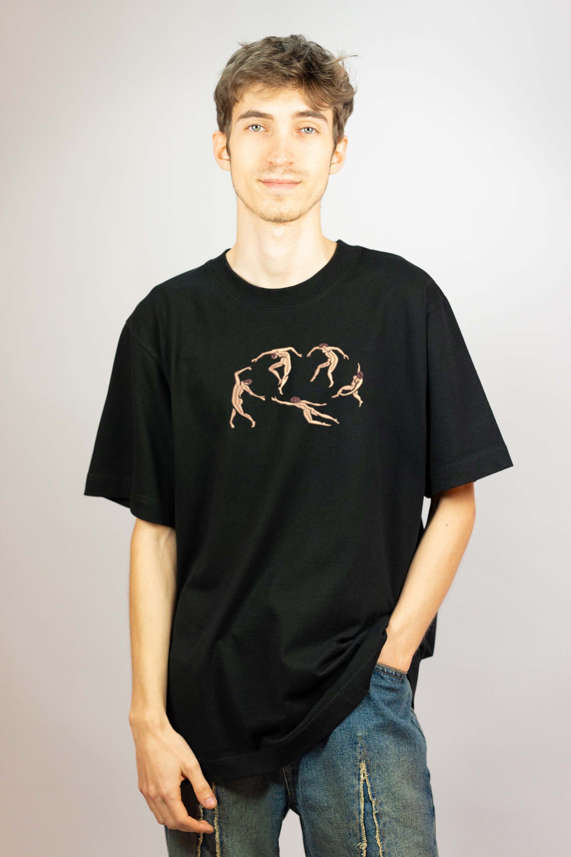 Art-inspired embroidered t-shirt showcasing a reinterpretation of Matisse’s "The Dance." The abstract figures in earthy tones contrast elegantly against the black fabric.