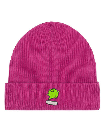 Căciulă roz din tricot cu manșetă întoarsă, brodată cu o broască simpatică pe un skate alb, un accesoriu drăguț și casual pentru orice ținută.