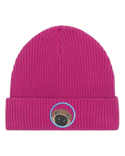 Căciulă roz din tricot cu manșetă întoarsă, brodată cu un patch circular cu față de pug, un accesoriu simpatic și jucăuș pentru iubitorii de câini.