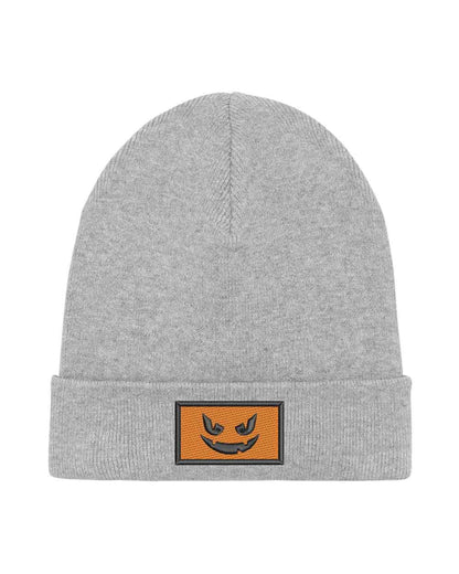Căciulă gri din tricot reiat cu manșetă întoarsă, brodată cu o față de dovleac Jack-o'-lantern neagră într-un chenar dreptunghiular, un accesoriu amuzant inspirat de Halloween.