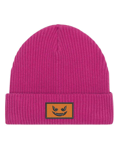 Căciulă roz din tricot reiat cu manșetă întoarsă, brodată cu o față de dovleac Jack-o'-lantern neagră într-un chenar dreptunghiular, un accesoriu amuzant inspirat de Halloween.