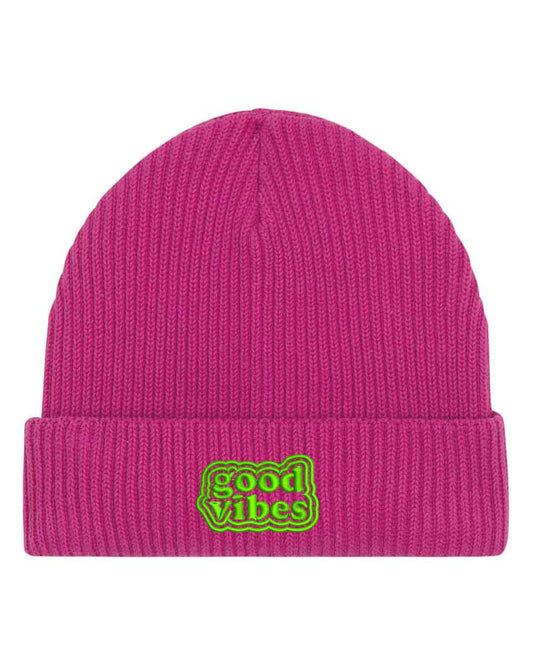 Căciulă roz din tricot reiat cu manșetă întoarsă, brodată cu patch verde și mesajul „Good Vibes” într-un font retro ondulat, un accesoriu pozitiv și modern pentru un stil casual.