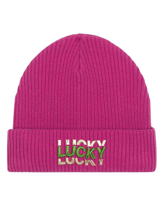 Căciulă roz din tricot reiat cu manșetă întoarsă, brodată cu mesajul „Lucky” în culori alb, verde și crem, un accesoriu modern și pozitiv pentru un stil casual.