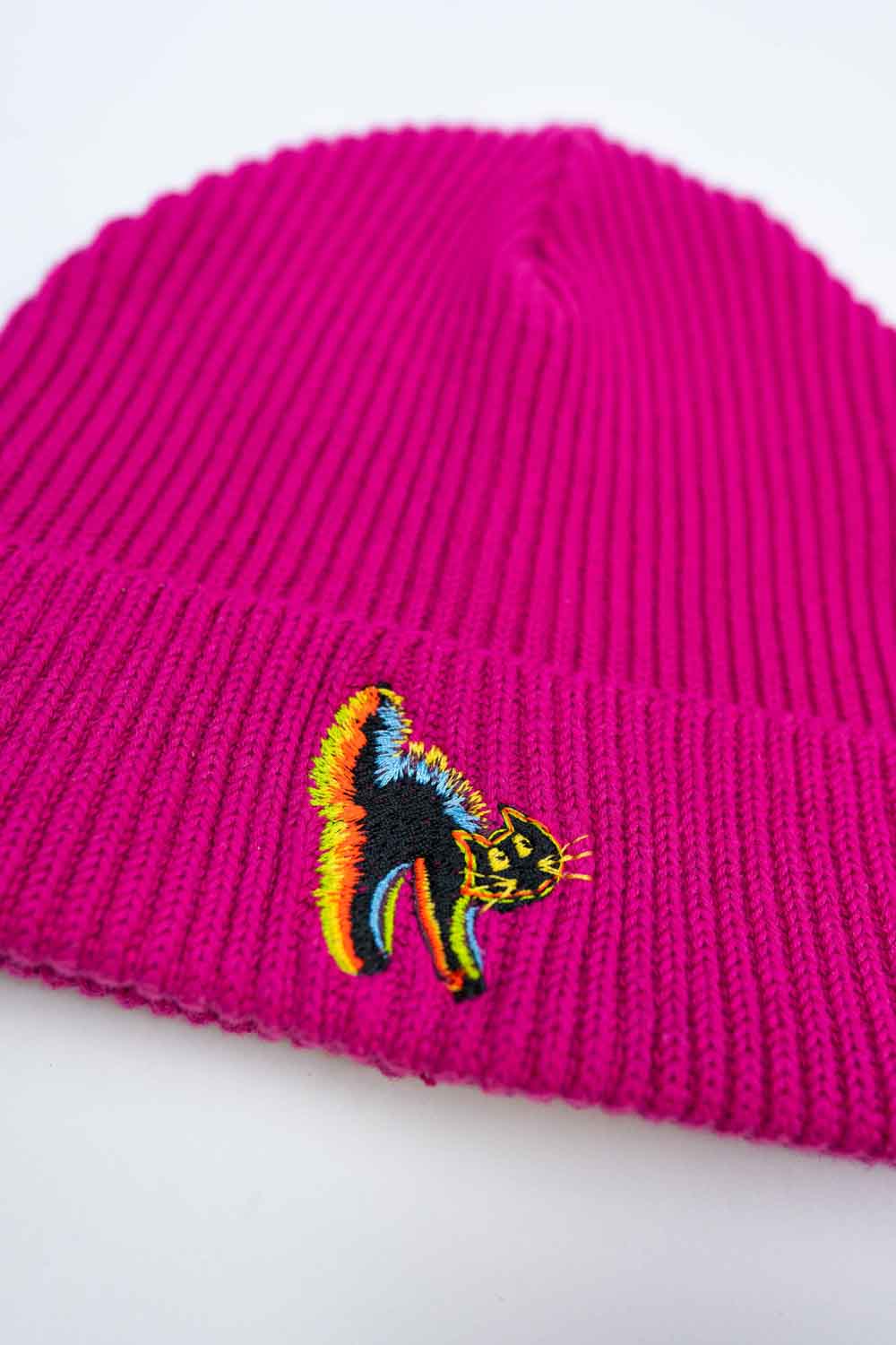 Căciulă roz din tricot reiat cu manșetă întoarsă, brodată cu un patch multicolor în formă de pisica pe partea frontală, un accesoriu delicat și colorat pentru un stil casual.