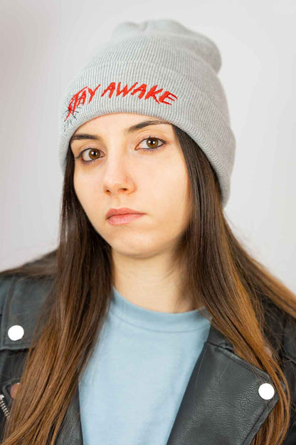 Căciulă gri din tricot cu manșetă întoarsă, brodată cu mesajul „Stay Awake” în roșu și un mic design de pânză de păianjen neagră, un accesoriu original și amuzant pentru un stil casual.