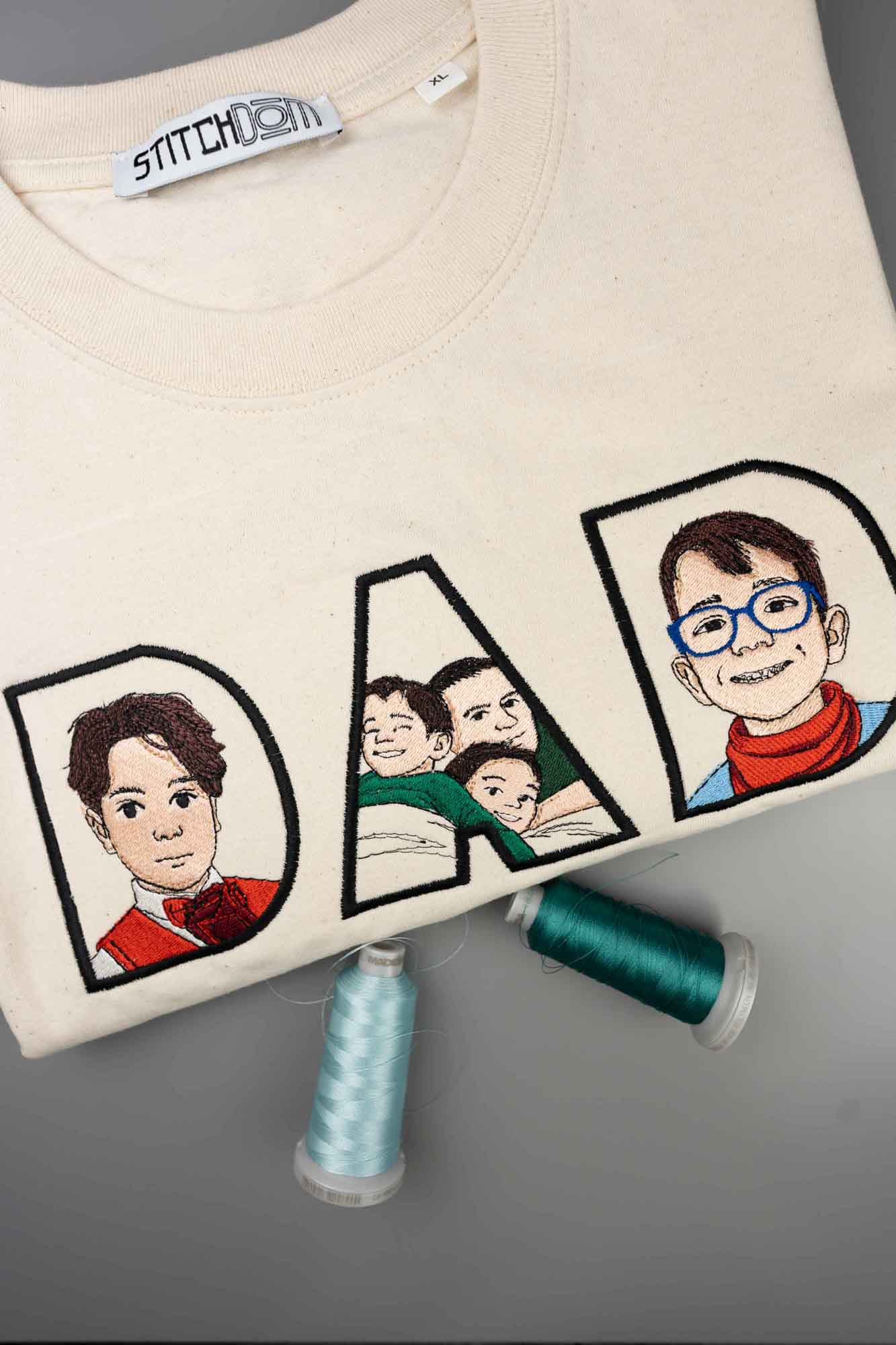 Tricou cu model brodat reprezentând textul „DAD”, cu imaginea unui bărbat zâmbitor și portrete mai mici în interiorul literelor, pe un fundal gri.