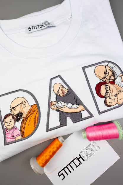 Tricou alb din bumbac organic, cu textul „DAD” realizat din litere mari brodate, fiecare literă având în interior o poză brodată personalizată în stil desen cu un tată și copilul său, pe o suprafață gri, alături de conuri de ață colorate și un card de brand „Stitchdom”.