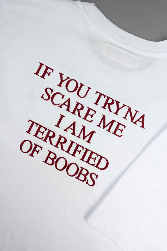 Tricou alb cu mânecă scurtă din bumbac organic, cu textul roșu „IF YOU TRYNA SCARE ME I AM TERRIFIED OF BOOBS” brodat pe partea din spate.