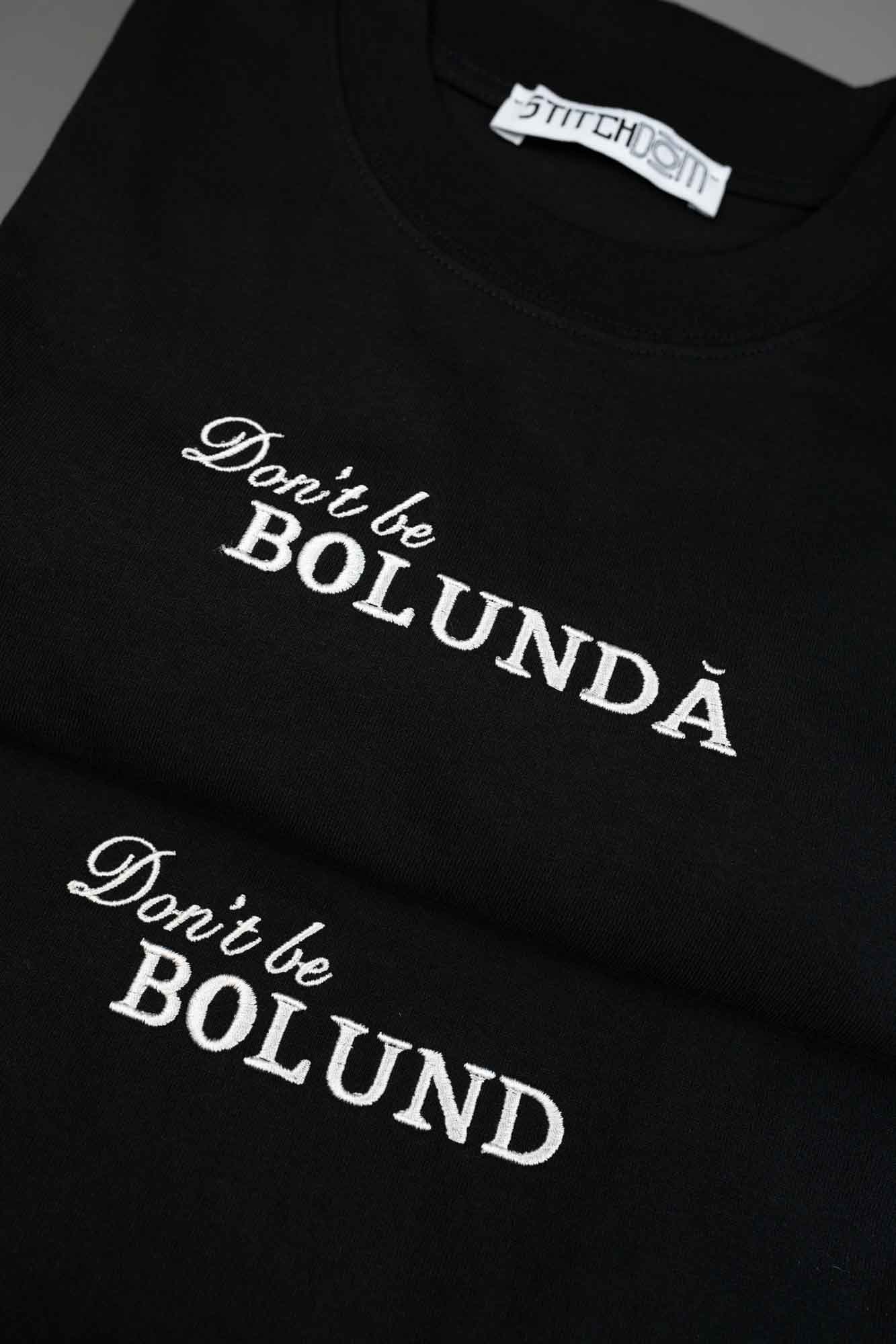 Tricou negru din bumbac organic, cu textele albe „Don't be BOLUNDĂ” și „Don't be BOLUND” brodate, cu o parte din eticheta interioară „Stitchdom” vizibilă.