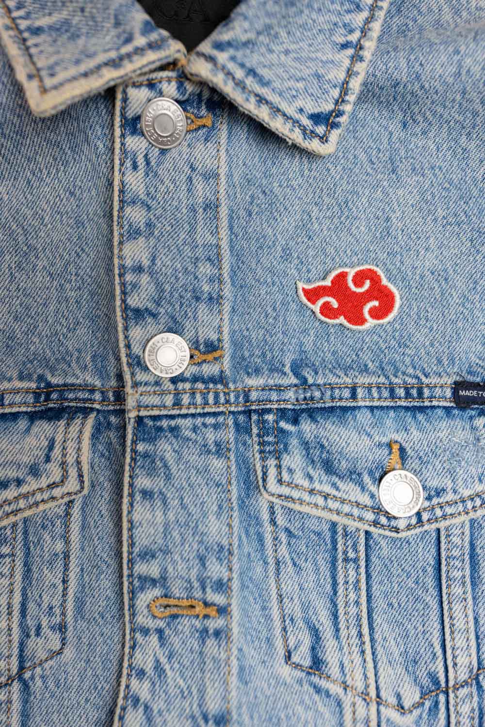 Patch brodat inspirat de Akatsuki din Naruto, cu design roșu și alb pe fundal negru, un accesoriu pentru fanii anime.