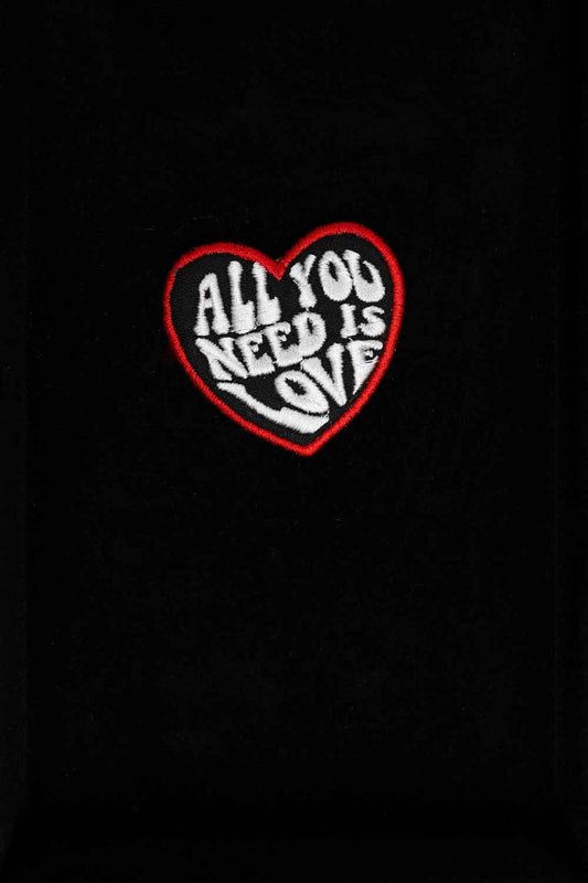 Patch brodat negru cu inimă roșie și mesajul „All You Need Is Love”, un accesoriu romantic și expresiv.