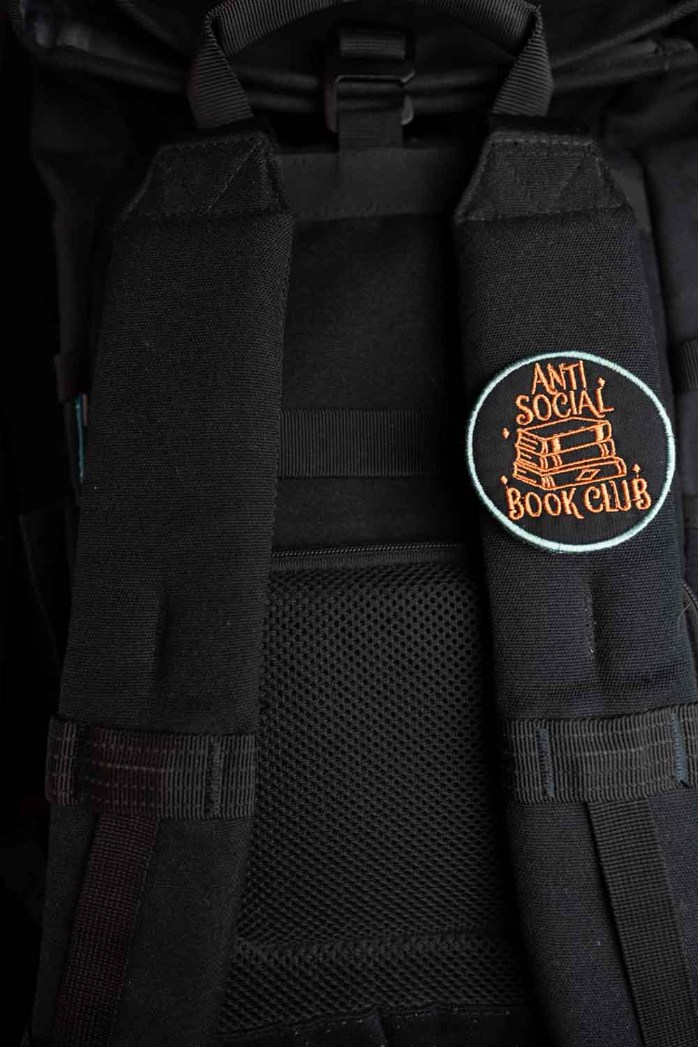 Patch brodat negru cu mesajul „Anti Social Book Club” și ilustrație de cărți, un accesoriu pentru pasionații de lectură.