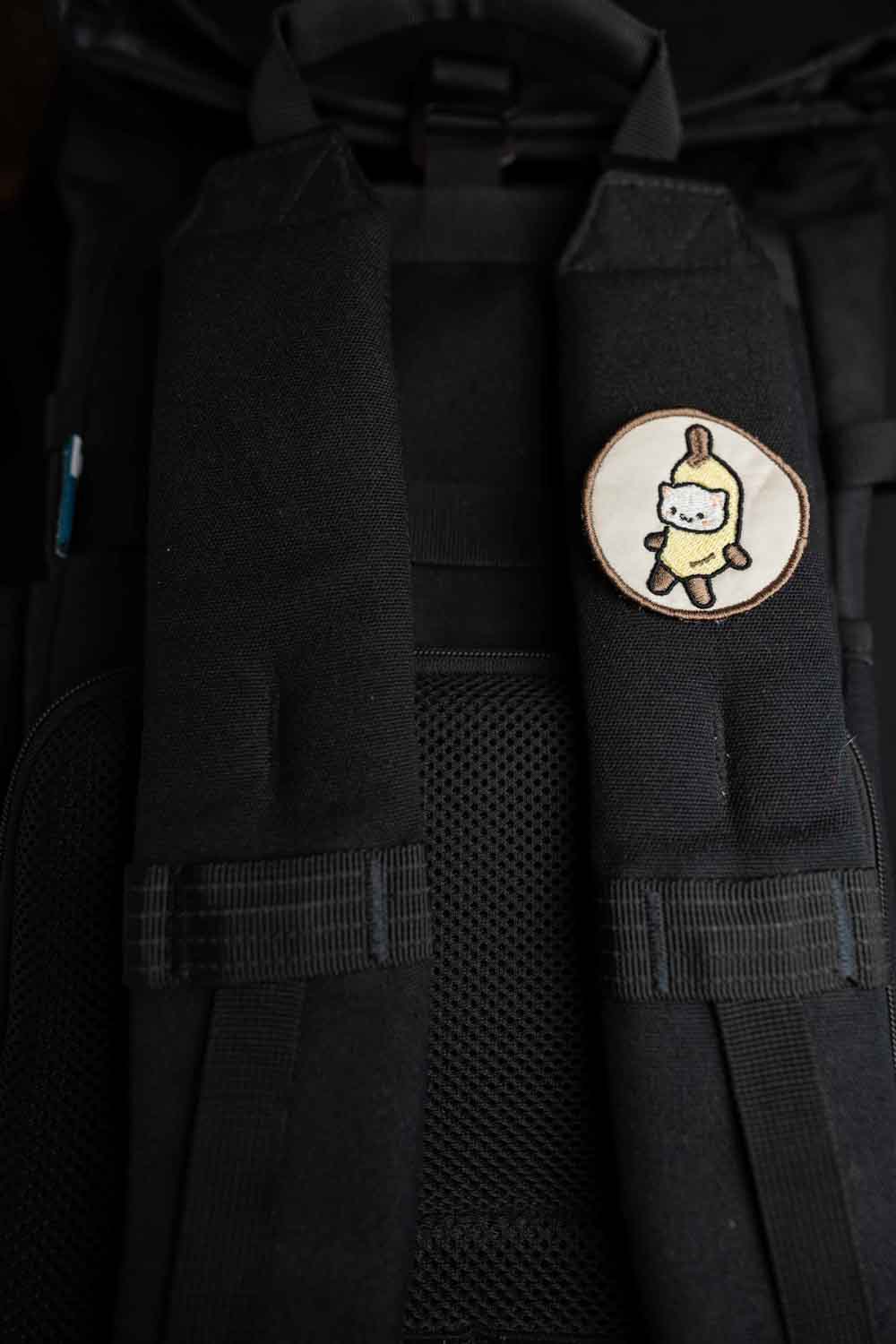 Patch brodat cu ilustrație de pisicuță într-o banană, un design kawaii și amuzant pentru personalizarea hainelor și genților.