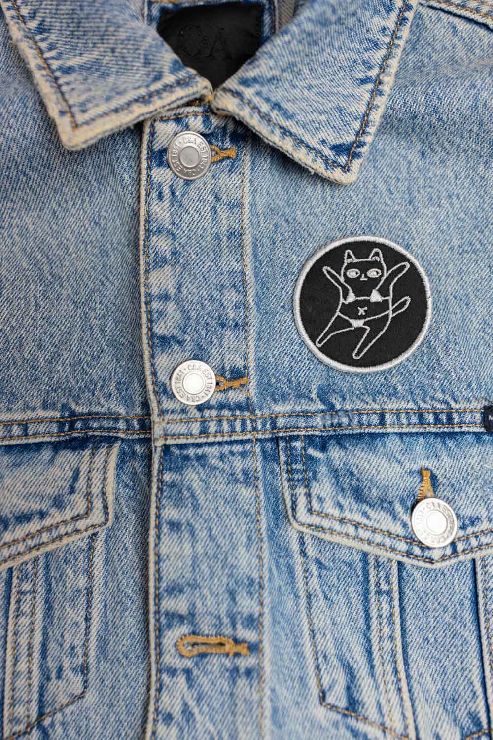 Patch brodat negru cu o pisică purtând ochelari de soare și sombrero, într-un design amuzant și colorat.