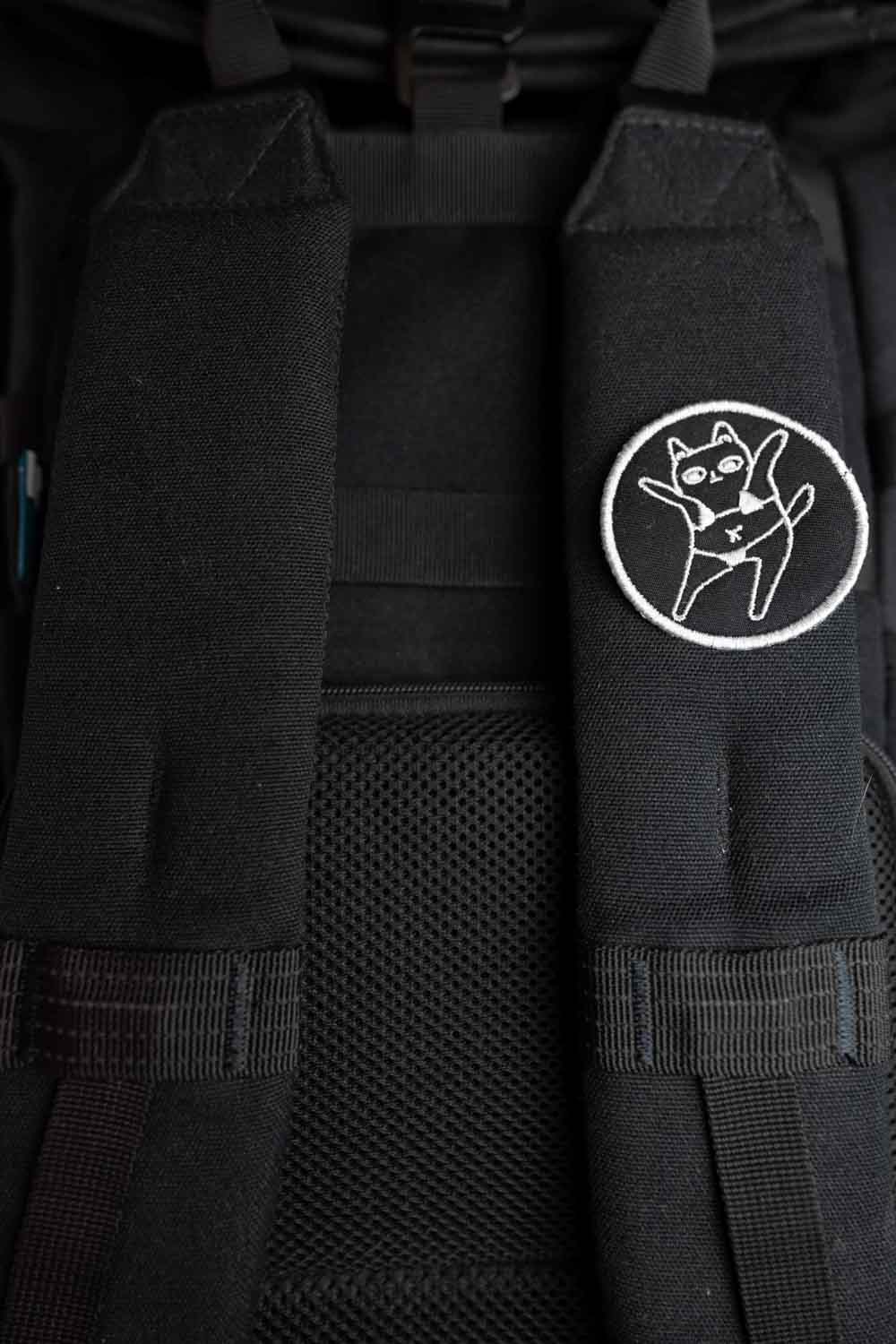 Patch brodat negru cu o pisică purtând ochelari de soare și sombrero, într-un design amuzant și colorat.