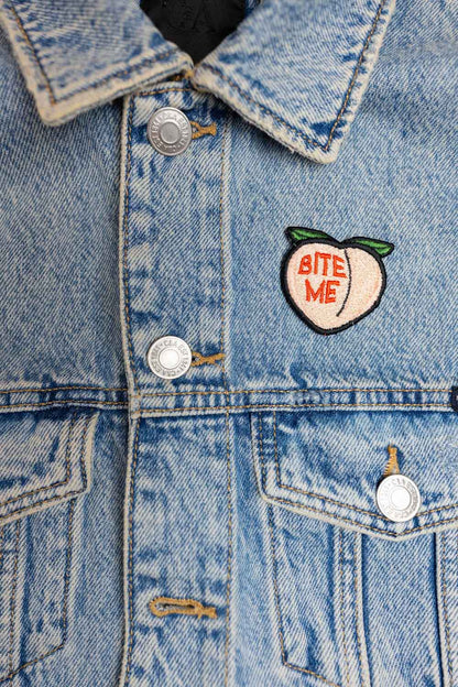 Patch brodat cu mesajul „Bite Me” pe design de fruct, un accesoriu amuzant și ironic pentru personalizare.