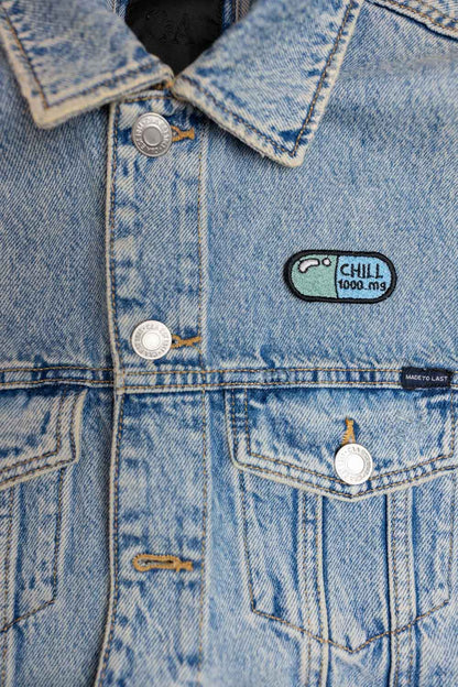 Patch brodat cu mesajul „Chill 1000 mg” pe un design inspirat de o etichetă de medicament, un accesoriu amuzant și creativ pentru personalizare.