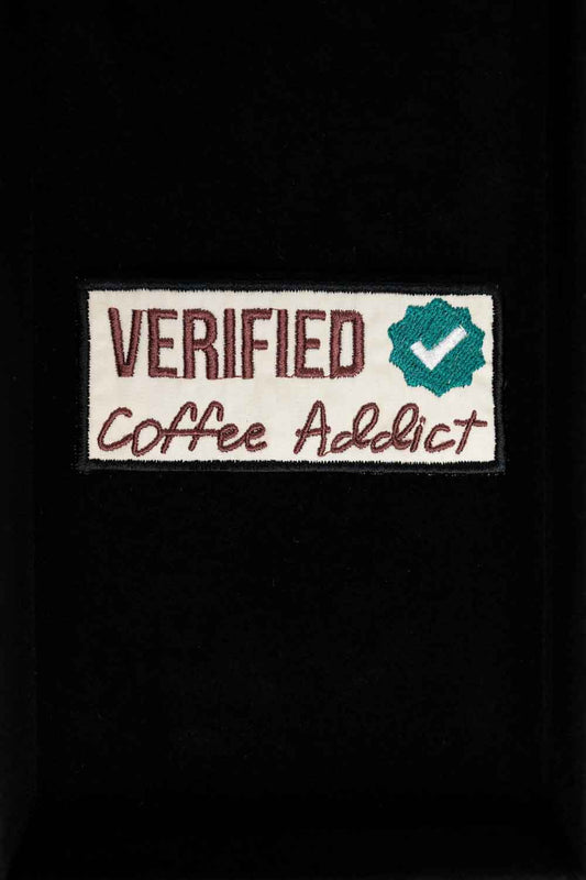 Patch brodat cu mesajul „Verified Coffee Addict” și simbol de verificare, un accesoriu perfect pentru iubitorii de cafea.