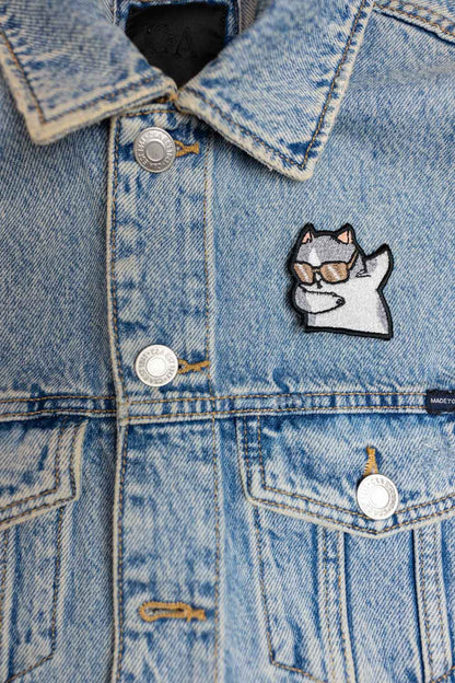 Patch brodat cu personaj stilizat purtând ochelari de soare și poziție dab, un accesoriu amuzant pentru haine și genți.