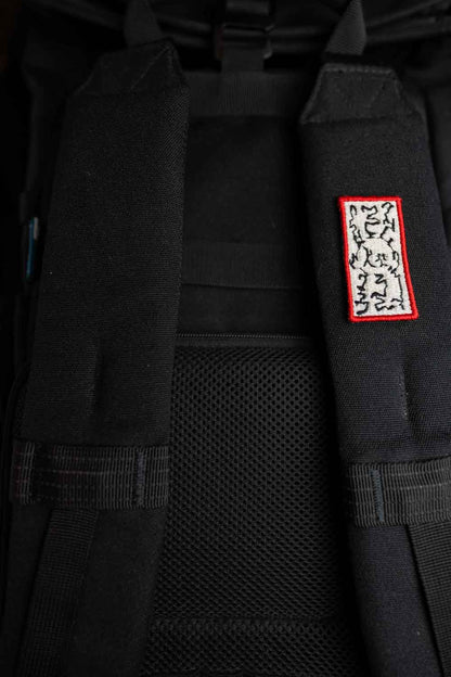 Patch brodat negru cu margine roșie și model floral alb în centru, un design elegant pentru personalizarea hainelor și accesoriilor.