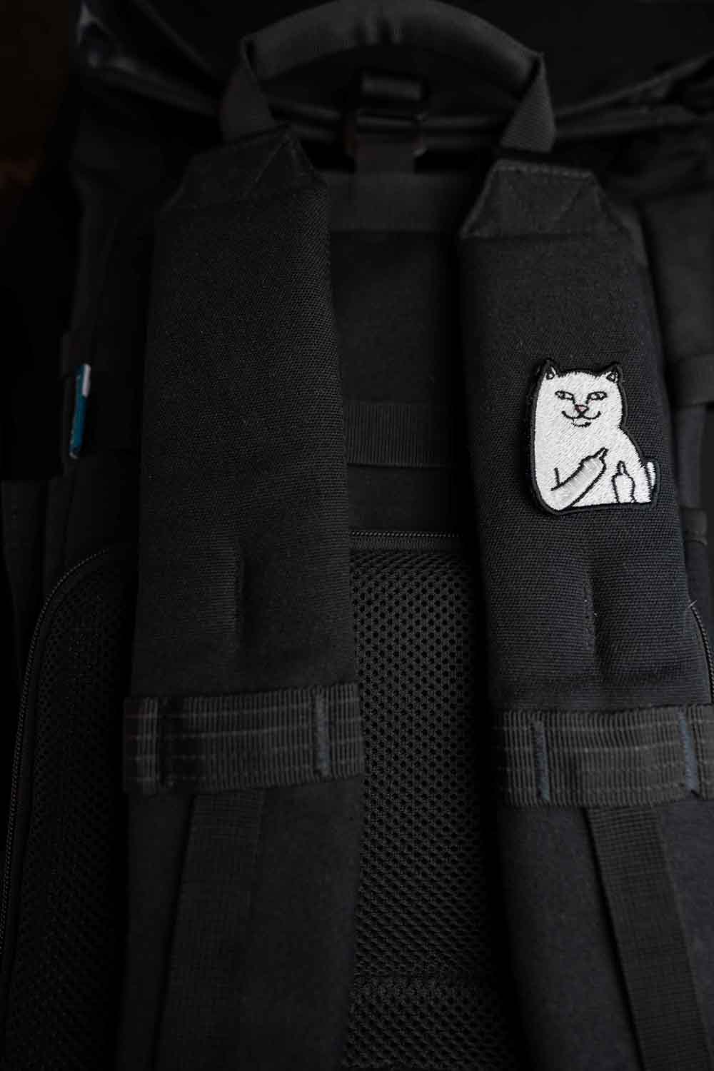 Patch brodat negru cu o pisică albă care arată degetul mijlociu, un design ironic și amuzant pentru personalizarea hainelor, genților sau accesoriilor.