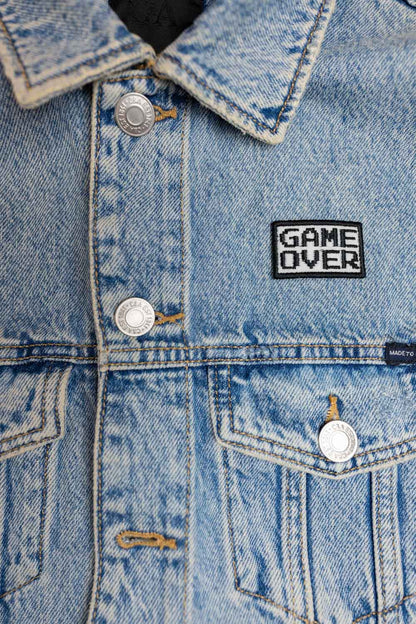 Patch brodat negru cu mesajul „Game Over” în alb, un accesoriu inspirat de jocurile video și cultura gaming.