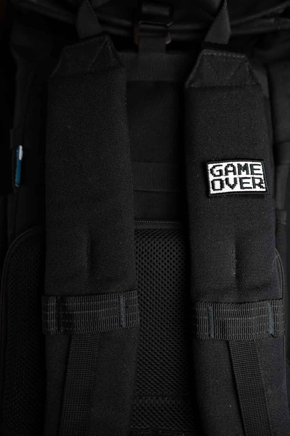 Patch brodat negru cu mesajul „Game Over” în alb, un accesoriu inspirat de jocurile video și cultura gaming.