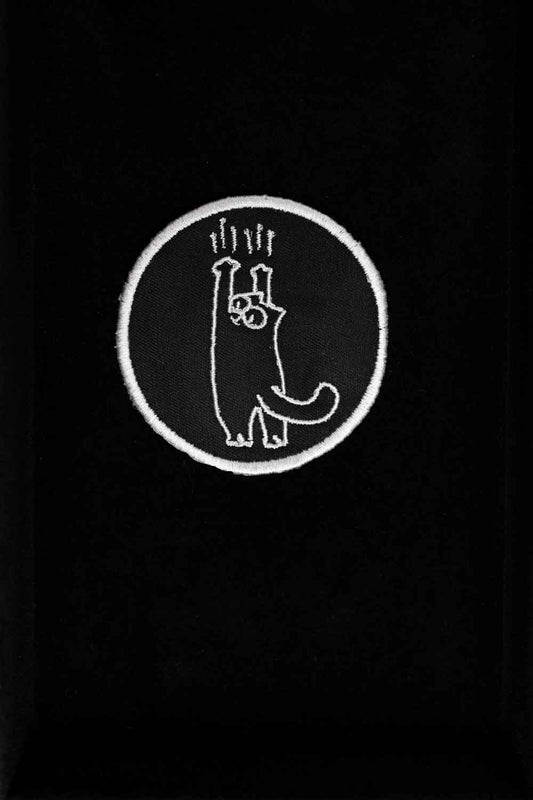 Patch brodat negru cu design alb al unei lăbuțe de pisică întinsă în sus, un accesoriu amuzant și creativ pentru personalizare.