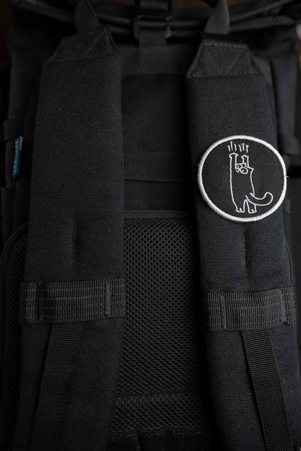 Patch brodat negru cu design alb al unei lăbuțe de pisică întinsă în sus, un accesoriu amuzant și creativ pentru personalizare.
