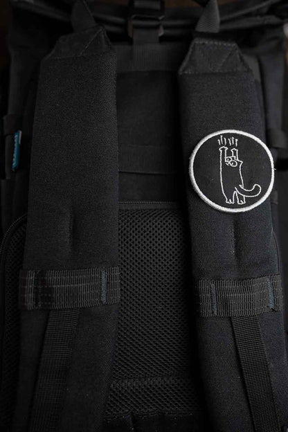 Patch brodat negru cu design alb al unei lăbuțe de pisică întinsă în sus, un accesoriu amuzant și creativ pentru personalizare.