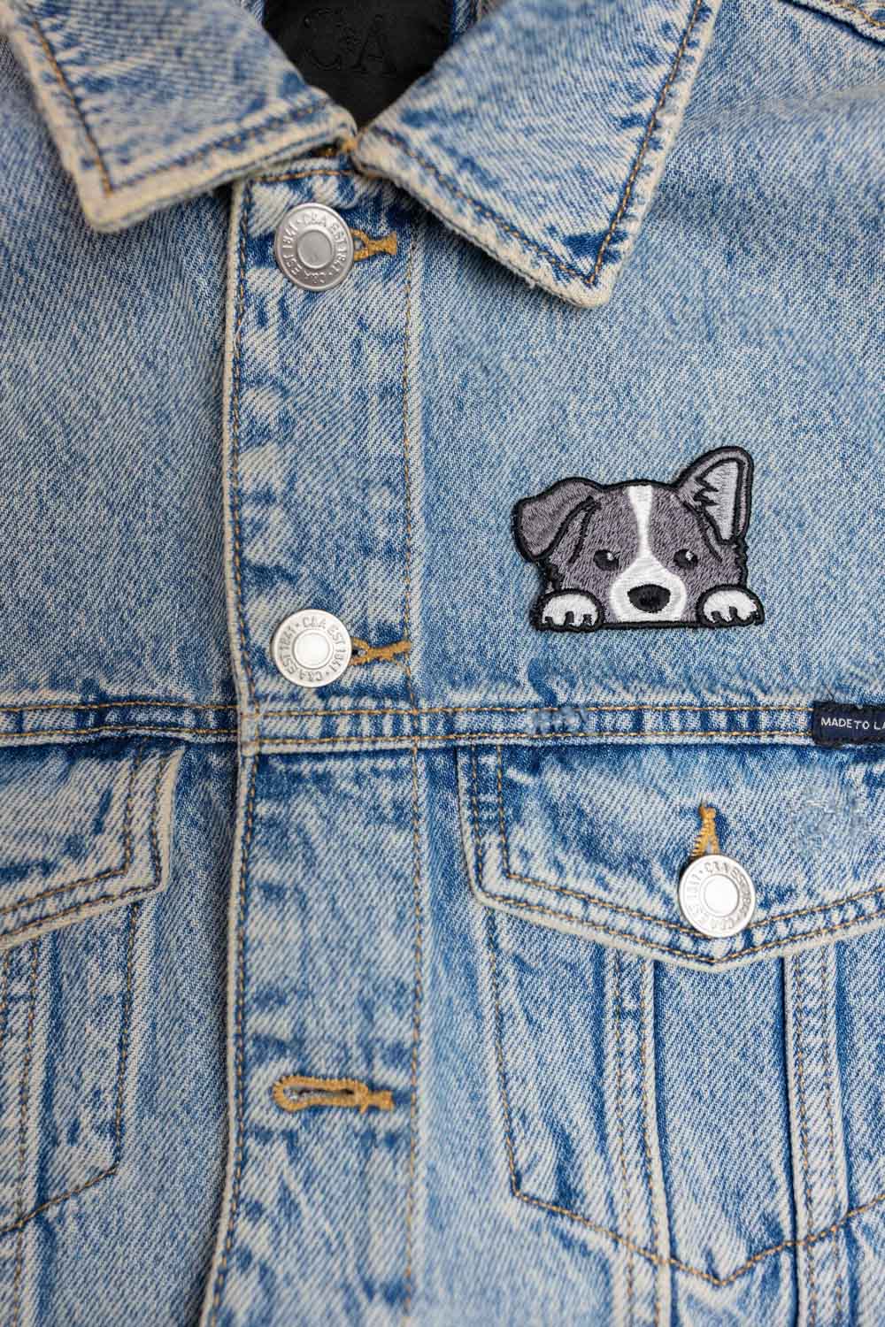 Patch brodat cu față de câine alb-negru, un accesoriu simpatic și minimalist pentru iubitorii de animale.