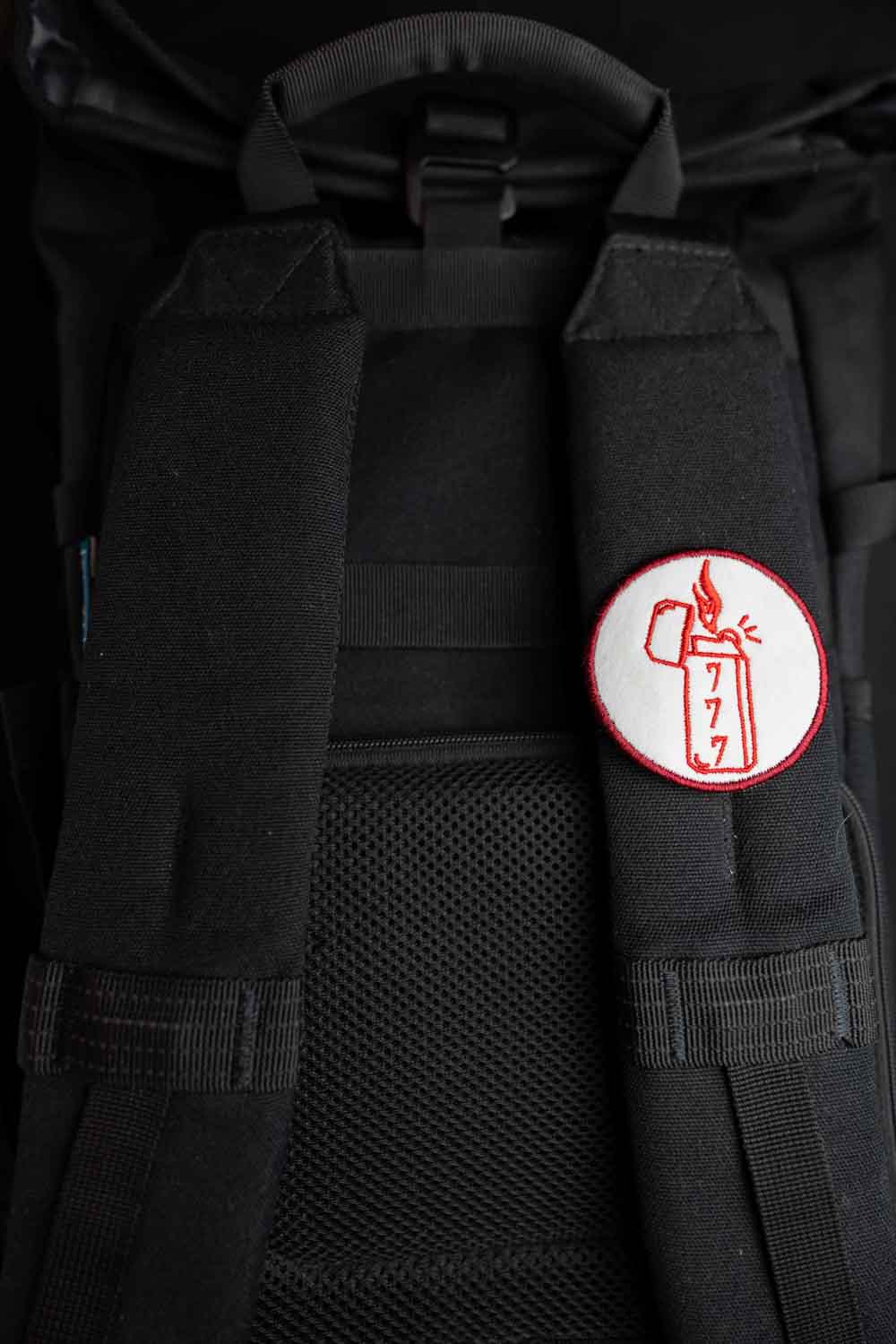 Patch brodat rotund cu design de brichetă, flacără și cifre în culori roșu și alb, un accesoriu original pentru haine și genți.