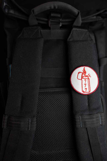 Patch brodat rotund cu design de brichetă, flacără și cifre în culori roșu și alb, un accesoriu original pentru haine și genți.