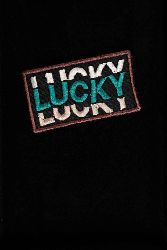 Patch brodat negru cu mesajul „Lucky” repetat într-un font stilizat, un accesoriu modern și expresiv.