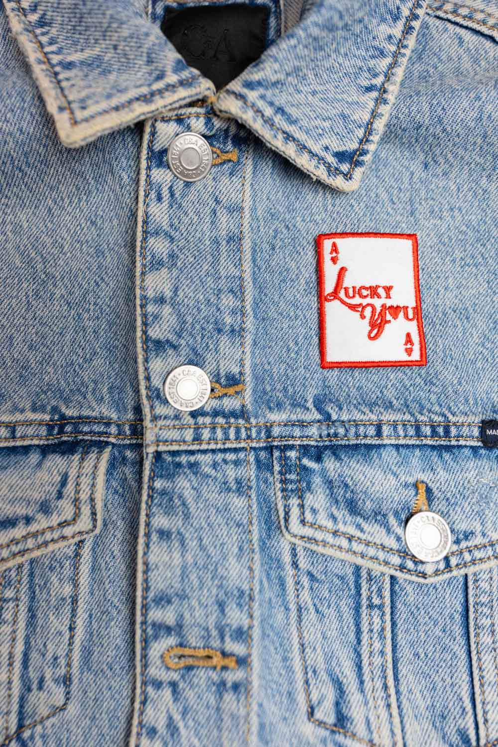 Patch brodat în formă de carte de joc cu mesajul „Lucky You”, un accesoriu inspirat de noroc și jocuri.