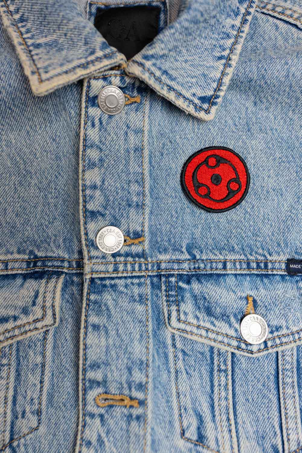 Patch brodat inspirat de Mangekyou Sharingan al lui Madara din Naruto, cu design roșu și negru, un accesoriu pentru fanii anime.