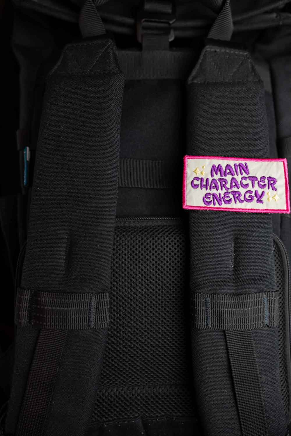 Patch brodat negru cu margine roz și mesajul „Main Character Energy”, un accesoriu amuzant și expresiv.