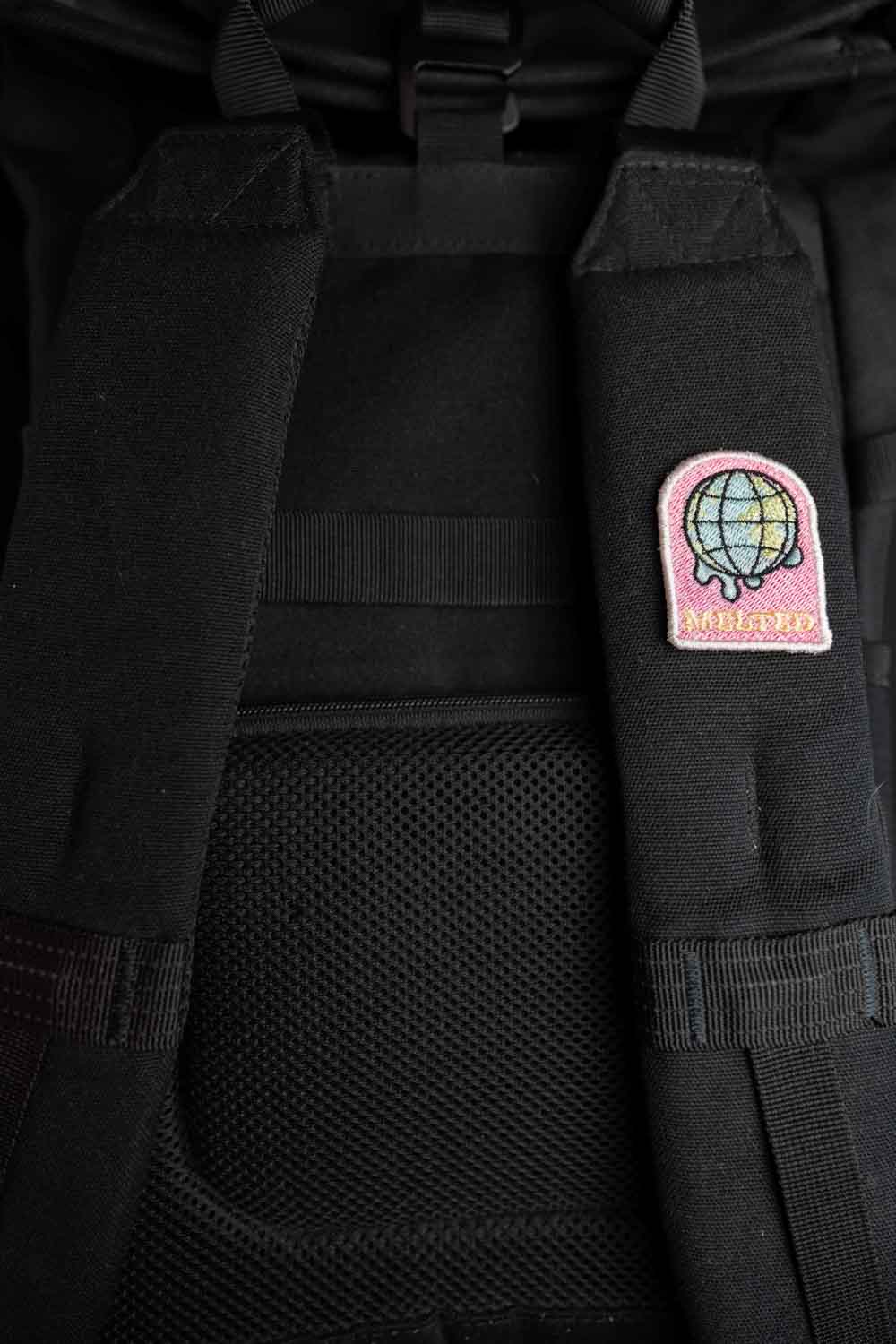 Patch brodat multicolor cu glob pământesc și mesajul „Melted”, un design artistic și original.