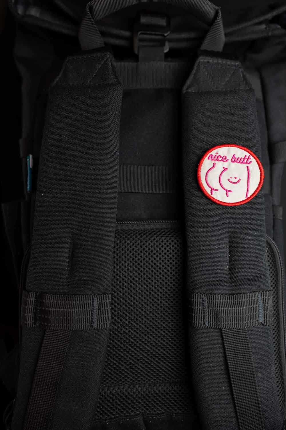 Patch brodat cu mesajul amuzant „Nice Butt” și față zâmbitoare, un accesoriu ironic și jucăuș pentru personalizare.