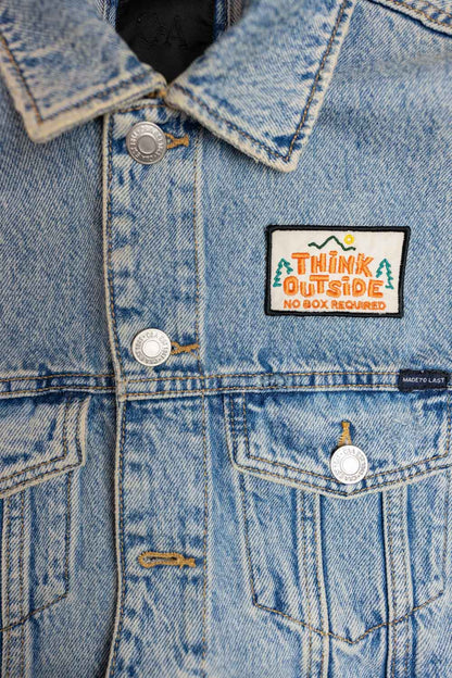 Patch brodat cu mesajul „Think Outside No Box Required”, un design creativ și amuzant pentru personalizarea hainelor și accesoriilor.