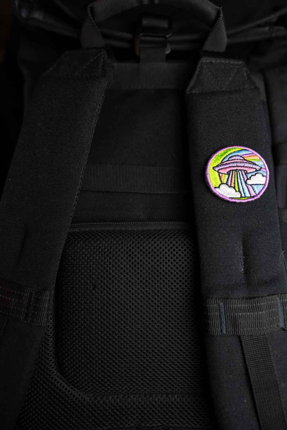 Patch brodat cu design colorat inspirat de un OZN pe fundal negru, un accesoriu creativ pentru iubitorii de modele neobișnuite.