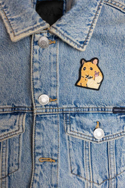 Patch brodat cu personaj galben în stil desen animat pe fundal negru, un design inspirat de muzica rock și stilul rebel.