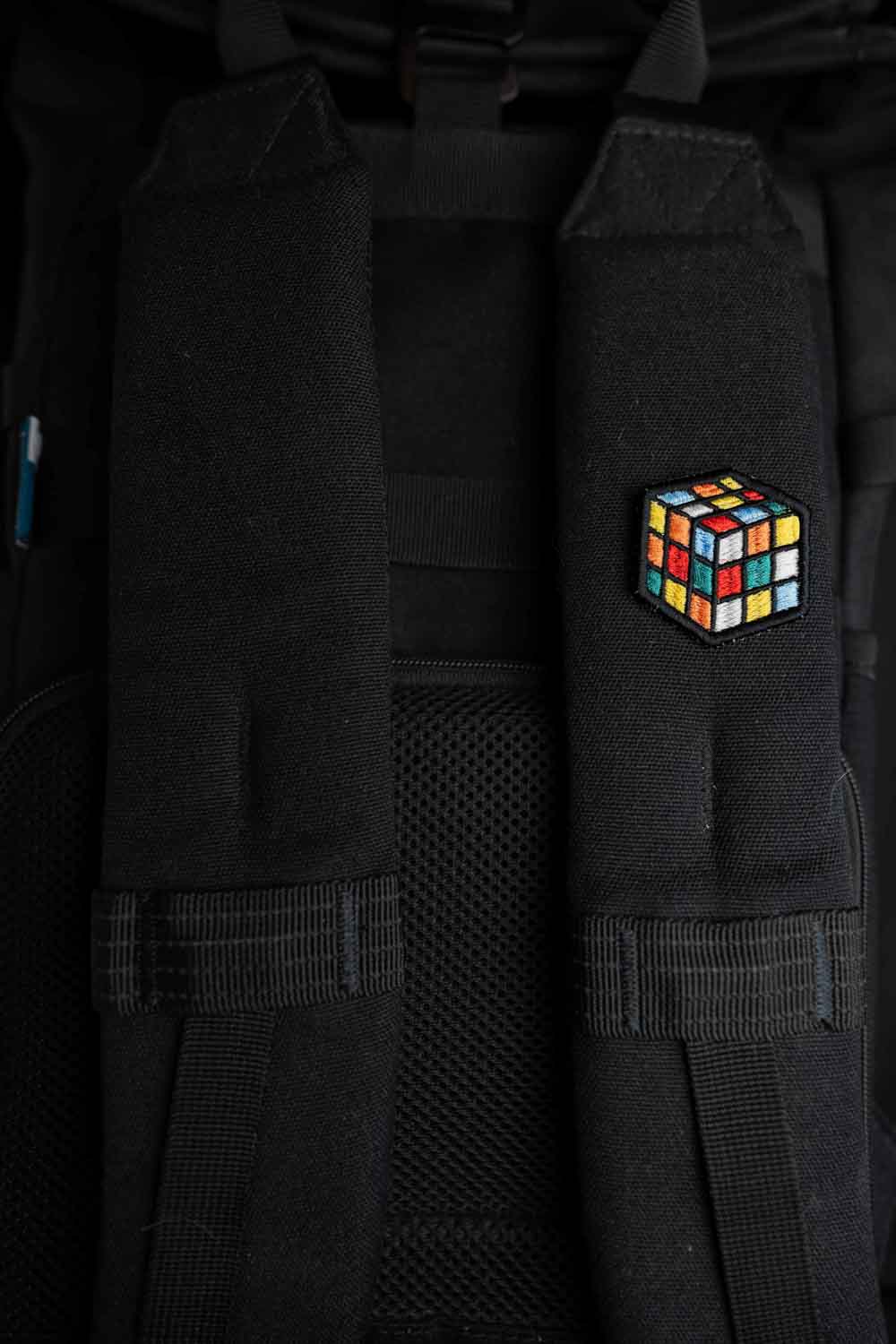Patch brodat cu design de cub Rubik colorat pe fundal negru, un accesoriu inspirat de jocurile clasice.
