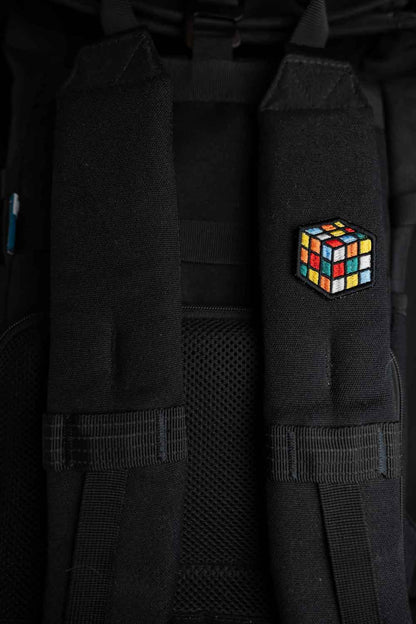 Patch brodat cu design de cub Rubik colorat pe fundal negru, un accesoriu inspirat de jocurile clasice.