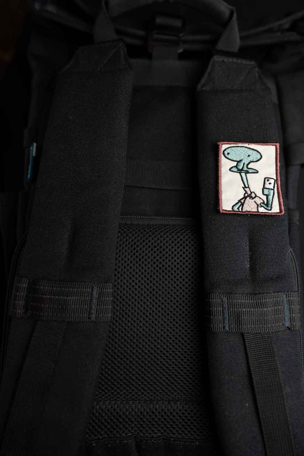 Patch brodat cu design amuzant inspirat de Patrick din SpongeBob, ținând o cameră foto pentru selfie, în culori roz și alb, un accesoriu creativ pentru personalizare.