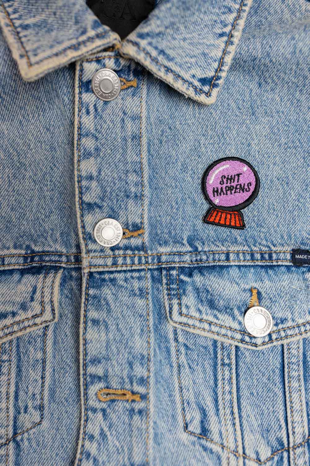 Patch brodat cu mesajul amuzant „Shit Happens”, un accesoriu ironic pentru personalizarea hainelor și genților.